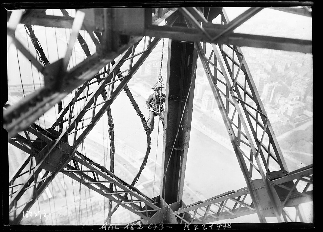 Peintre travaillant suspendu dans la structure de la tour Eiffel en 1932 Peintre travaillant suspendu dans la structure de la tour Eiffel en 1932