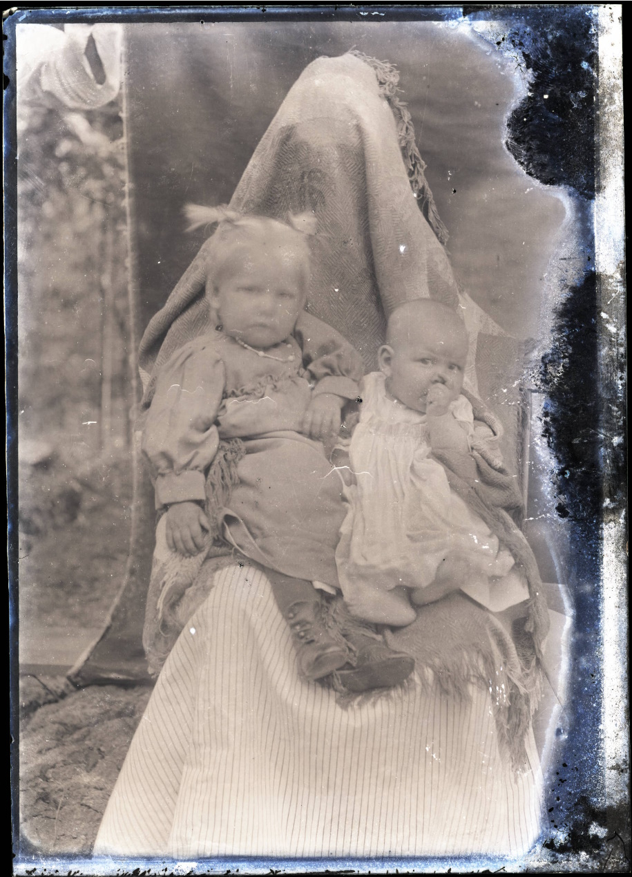 Deux enfants photographiés avec un adulte caché derrière eux par Albert J. Ewing Deux enfants photographiés avec un adulte caché derrière eux par Albert J. Ewing