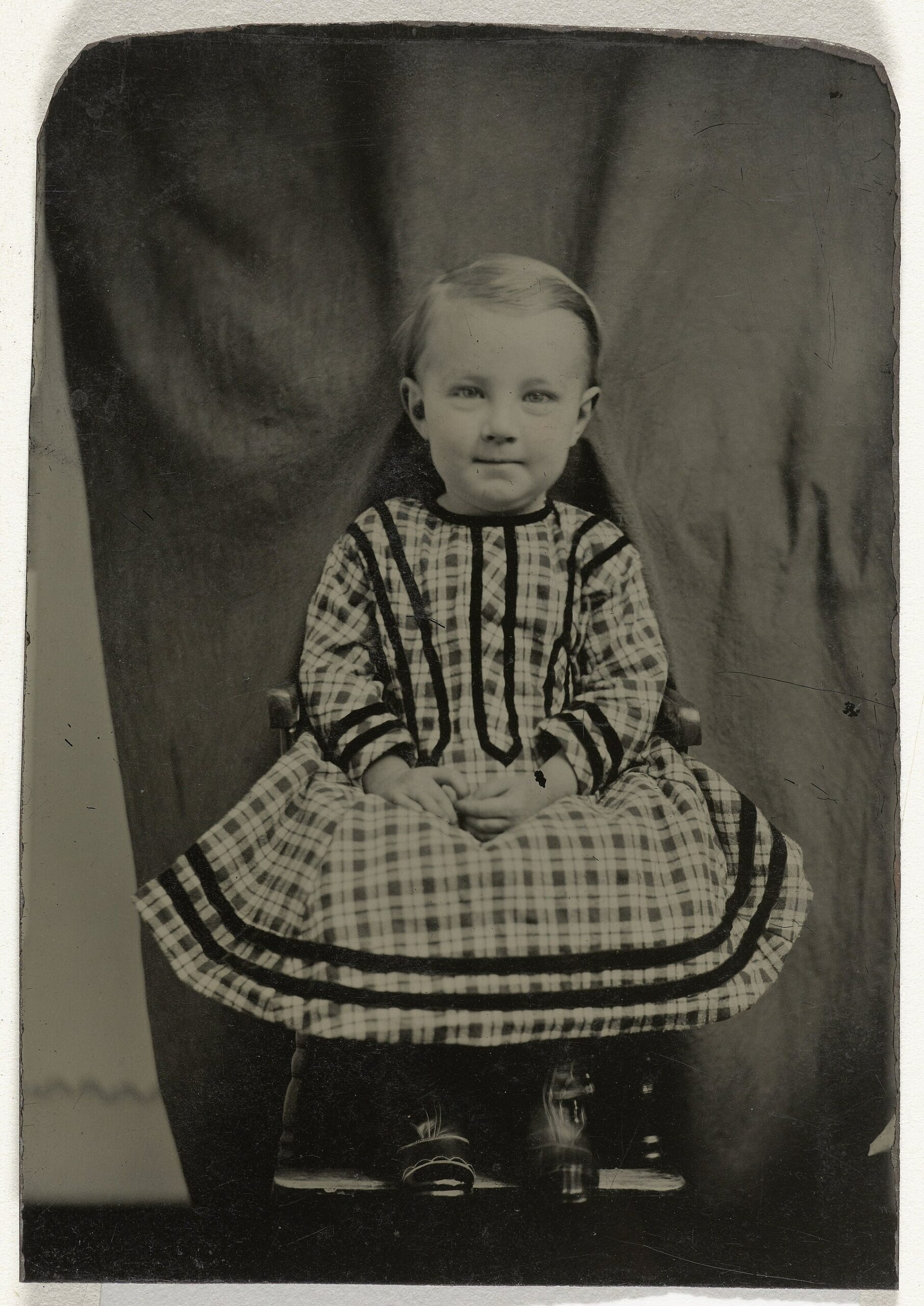 Enfant assis devant sa mère cachée dans le décor Portrait d'enfant assis avec sa mère dissimulée sous le décor derrière sa chaise
