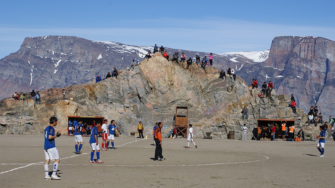 Uummannaq en été avec son terrain de football et les montagnes du Groenland Uummannaq en été avec son terrain de football et les montagnes du Groenland