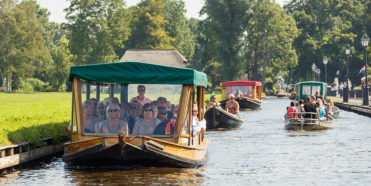 Bateaux dans les canaux de Giethoorn Visiteurs naviguant à bord de petites embarcations sur un canal de Giethoorn aux Pays-Bas