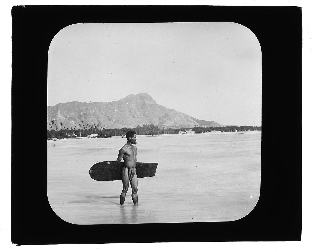 Charles Kauha avec une planche de surf alaia à Waikiki en 1898 Charles Kauha avec une planche de surf alaia à Waikiki en 1898