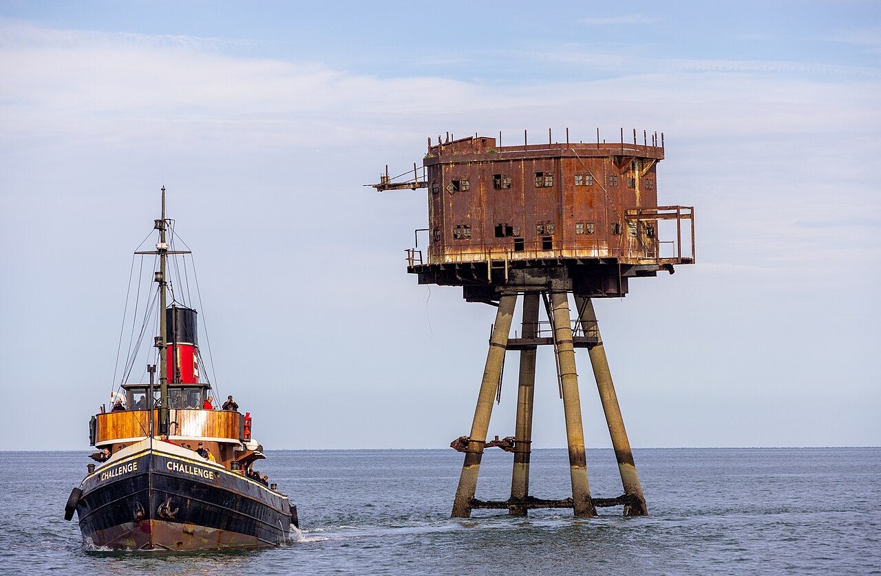 Bateau devant une tour du fort Maunsell de Red Sands dans l'estuaire de la Tamise Bateau devant une tour du fort Maunsell de Red Sands dans l'estuaire de la Tamise