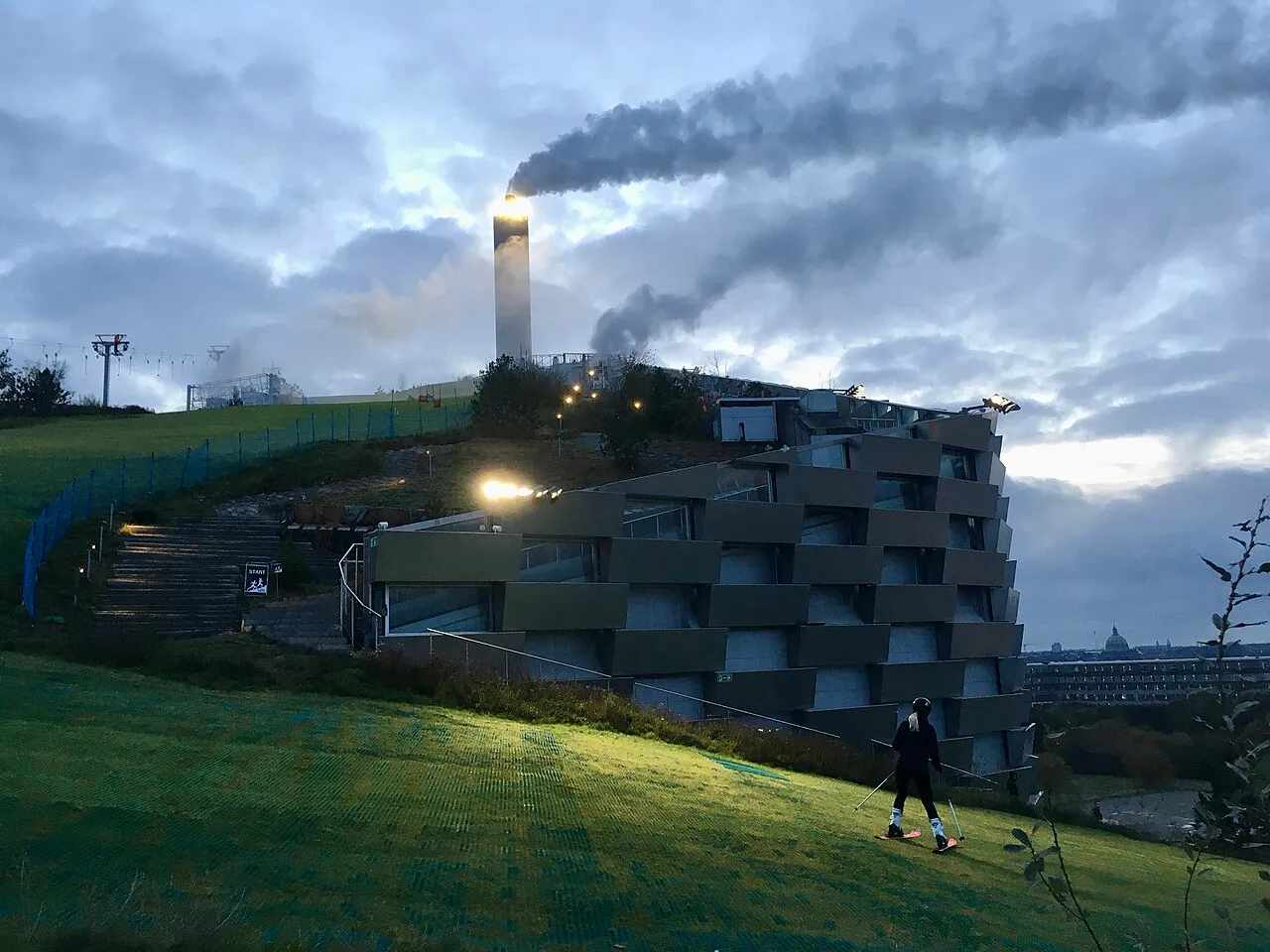 Skieurs descendant la piste synthétique CopenHill sur le toit d’Amager Bakke à Copenhague Skieurs descendant la piste synthétique CopenHill sur le toit d’Amager Bakke à Copenhague