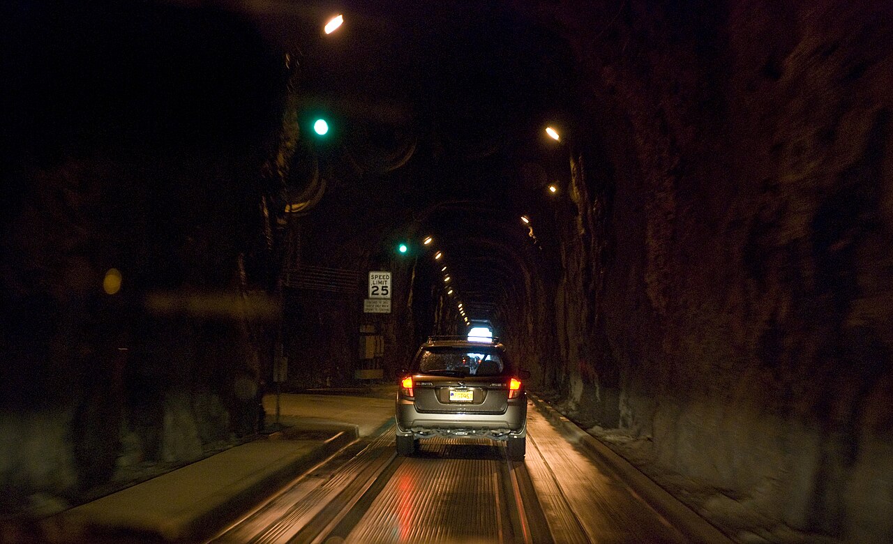 Intérieur du tunnel de Whittier où voitures et trains utilisent la même voie Intérieur du tunnel de Whittier où voitures et trains utilisent la même voie