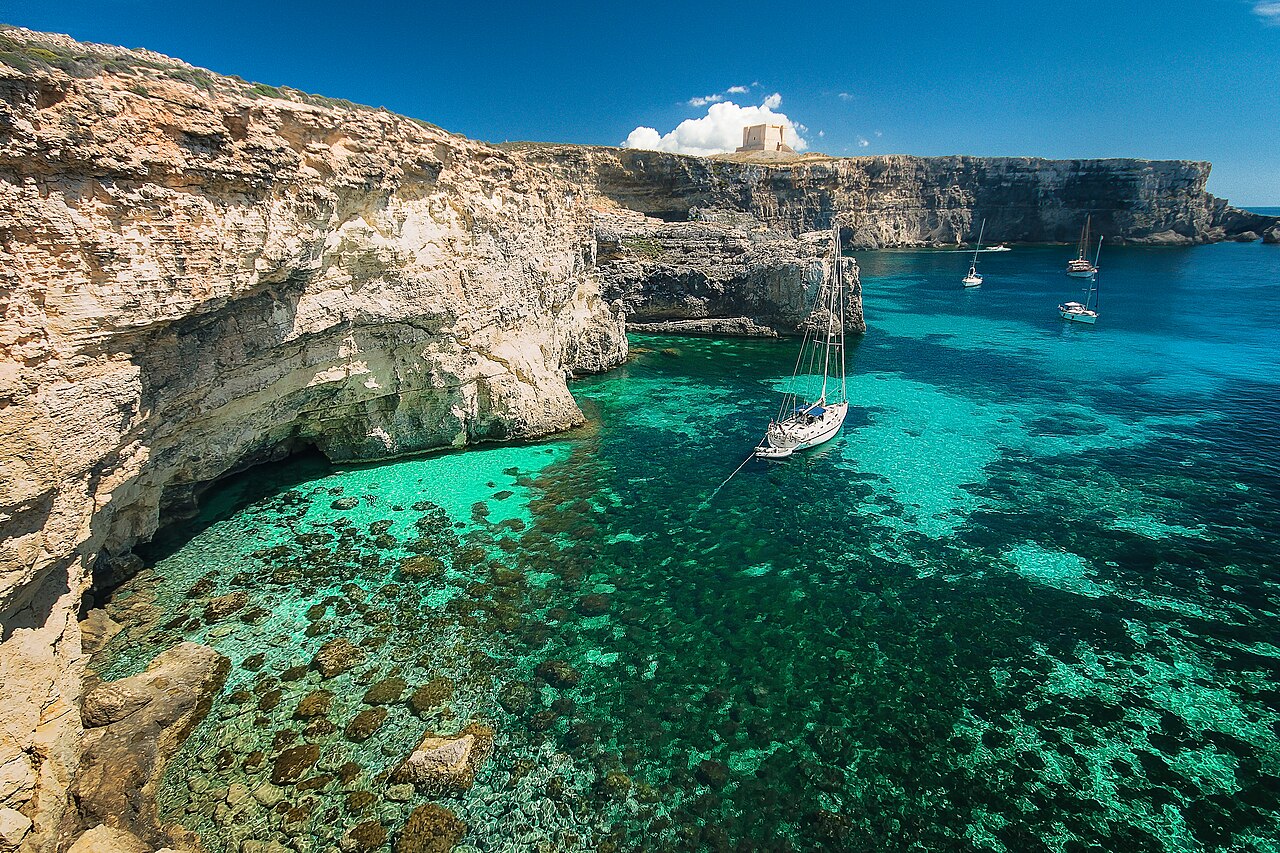 Bateau dans les eaux turquoise du Blue Lagoon de Comino Bateau dans les eaux turquoise du Blue Lagoon de Comino