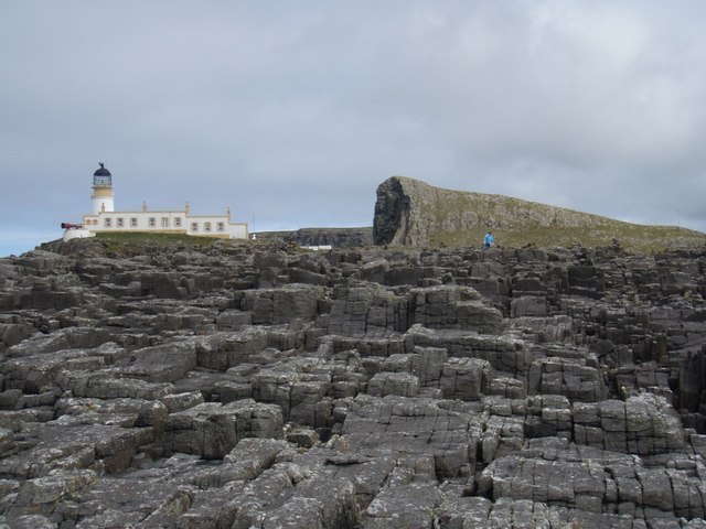 Pavage basaltique de Neist Point avec le phare en arrière-plan Pavage basaltique de Neist Point avec le phare en arrière-plan