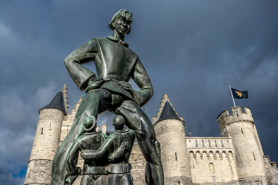 Lange Wapper : la statue géante d’Anvers qui fait lever les yeux un peu trop haut lange wapper statue geante anvers La statue géante de Lange Wapper dominant deux hommes devant Het Steen à Anvers