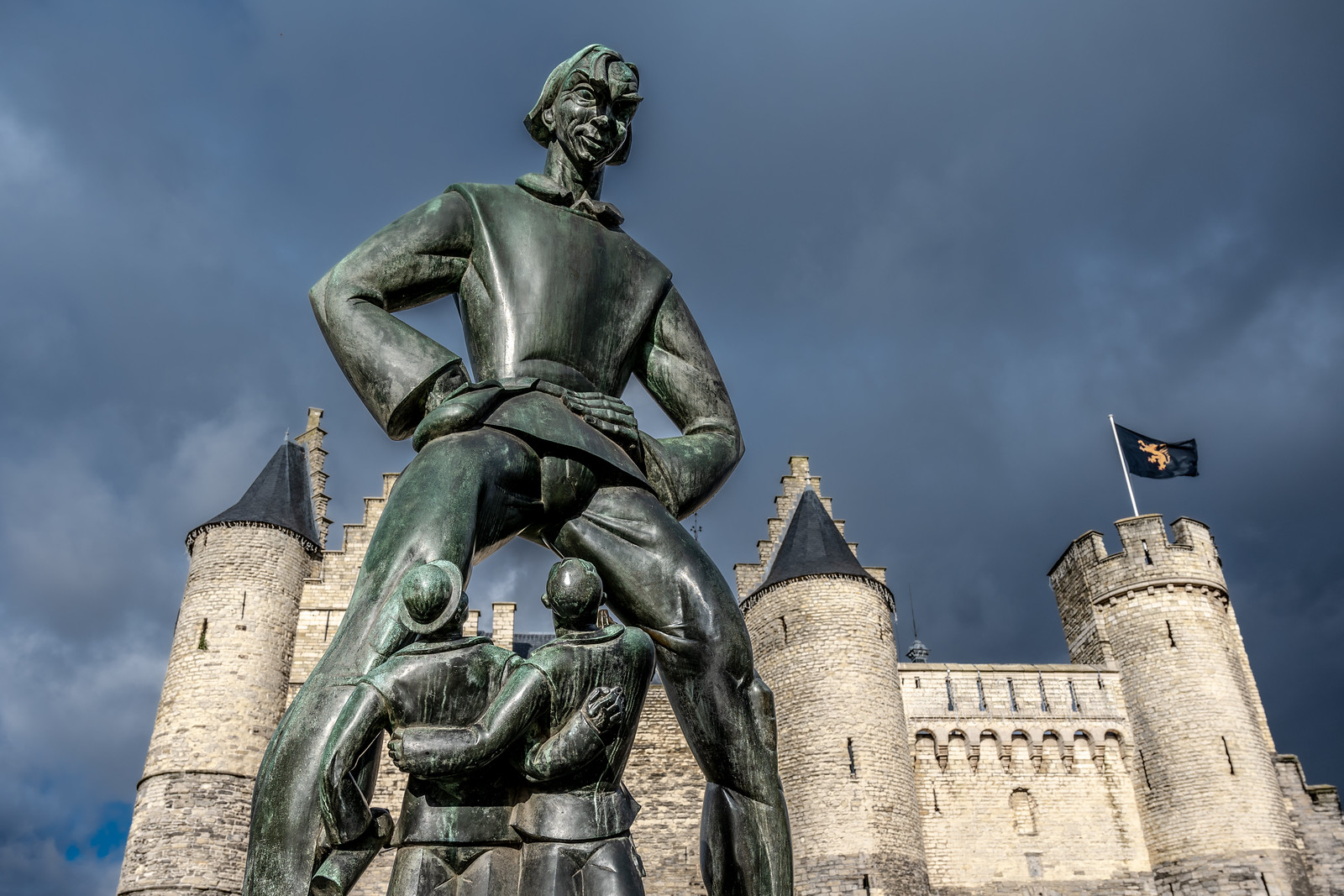 lange wapper statue geante anvers La statue géante de Lange Wapper dominant deux hommes devant Het Steen à Anvers