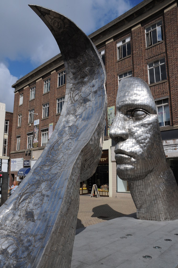 les deux visages en acier de la sculpture Reflections of Bedford vus de profil les deux visages en acier de la sculpture Reflections of Bedford vus de profil