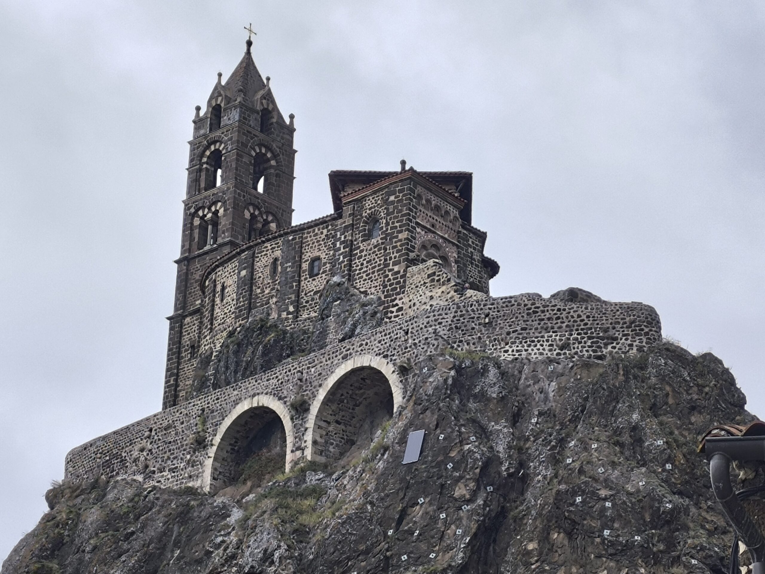 chapelle saint michel aiguilhe rocher volcanique Chapelle Saint-Michel d'Aiguilhe vue en contre-plongée avec son clocher et ses arcades bâties sur le rocher volcanique