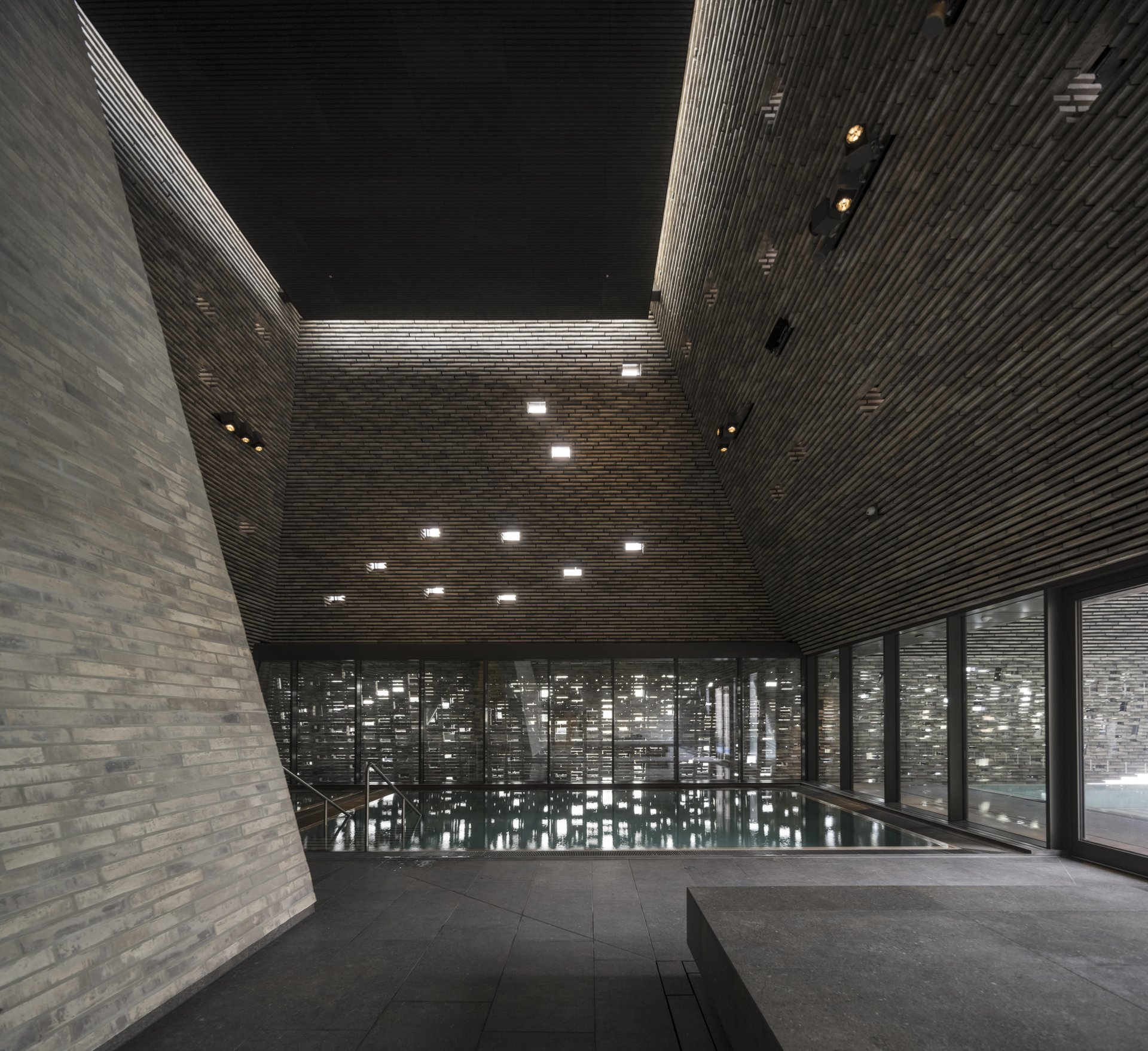 kai copenhague architecture interieure Bassin intérieur de KAI entouré de parois de briques percées de petites ouvertures lumineuses.