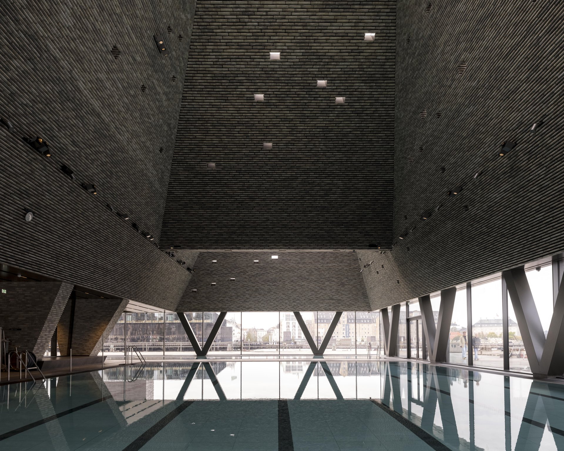 kai copenhague piscine interieure Grande piscine intérieure de KAI sous une structure de briques, face aux baies vitrées donnant sur le port.