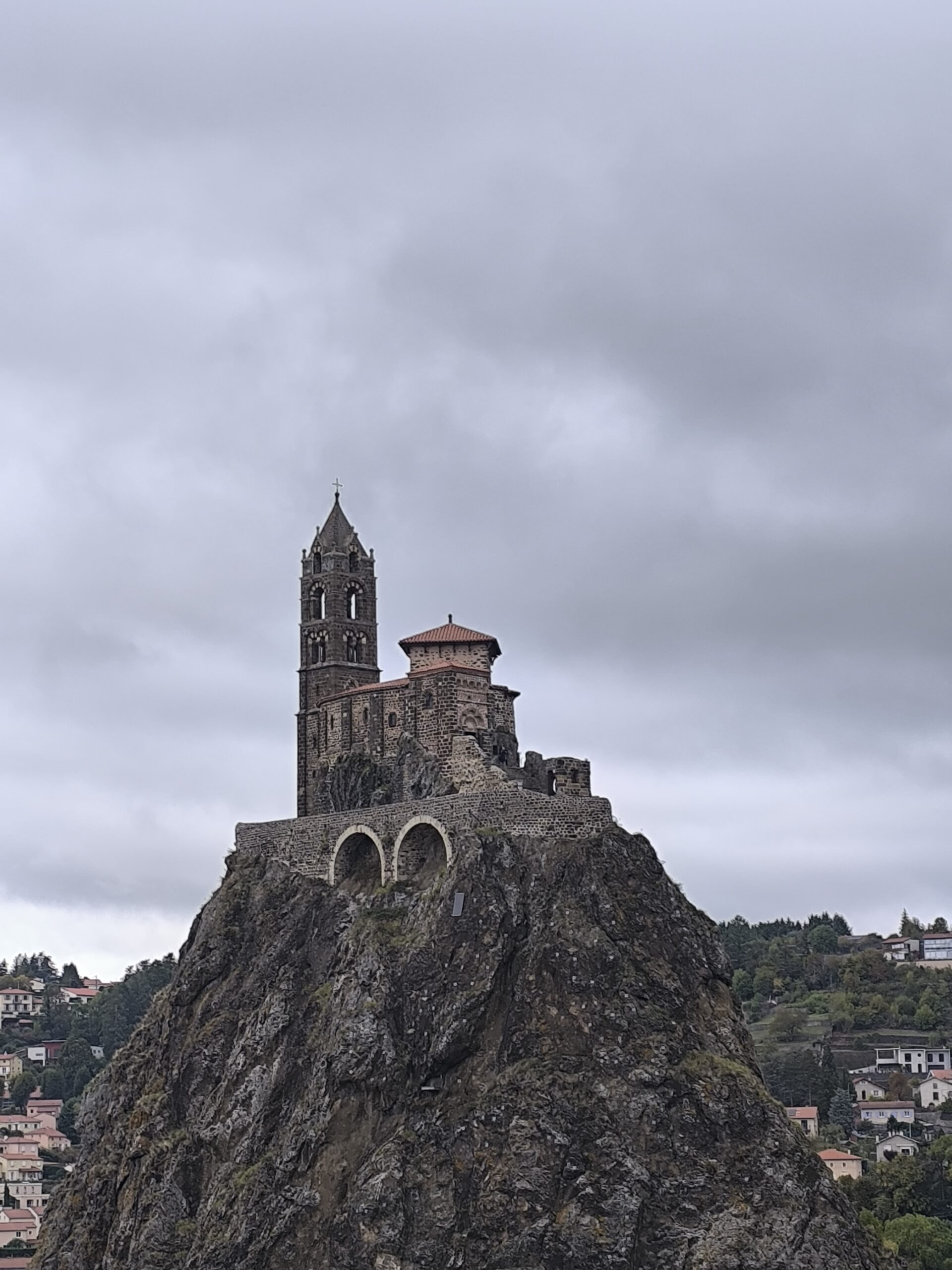 rocher saint michel aiguilhe vue generale Le rocher volcanique Saint-Michel d'Aiguilhe surmonté de sa chapelle romane, sous un ciel nuageux